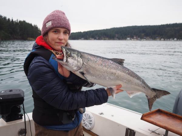 Angler holds up a blackmouth salmon she caught