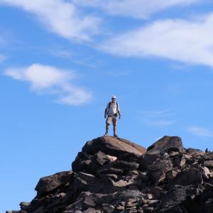 A hiker stands at the summit of Bear Creek mountain